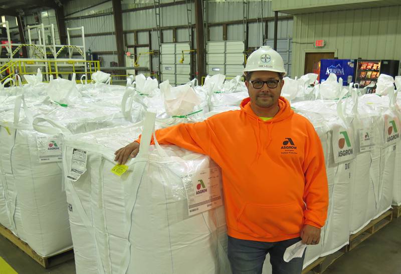 Approximately 2.3 million units, or bags, of soybean seed are shipped each year from the Bayer Commercial Soybean Processing Facility in Stonington, Illinois. Sam Weller, seed technician, stands next to some of the Asgrow units ready for shipping.