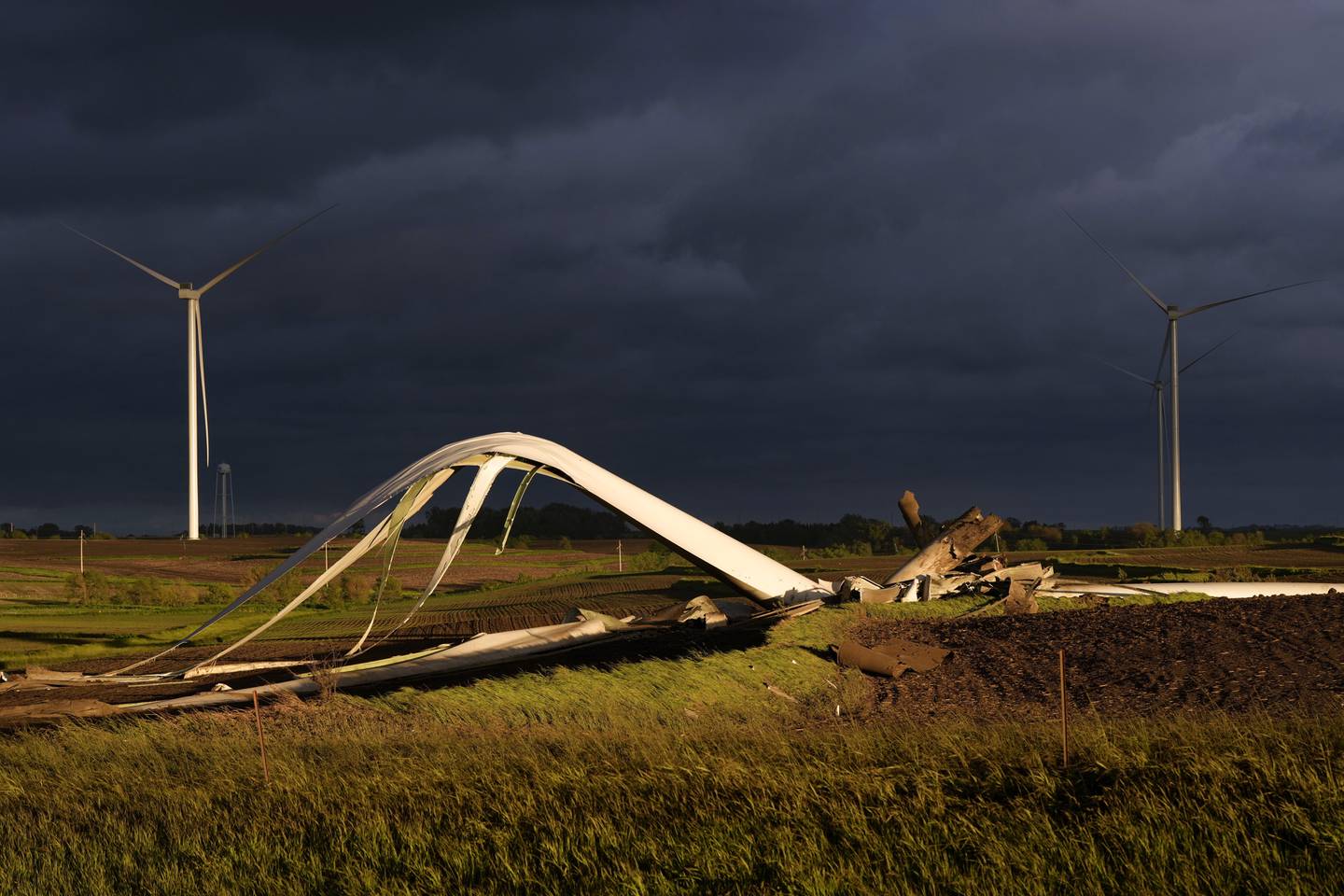 The remains of a tornado-damaged wind turbine touch the ground in a field May 21 near Prescott, Iowa.