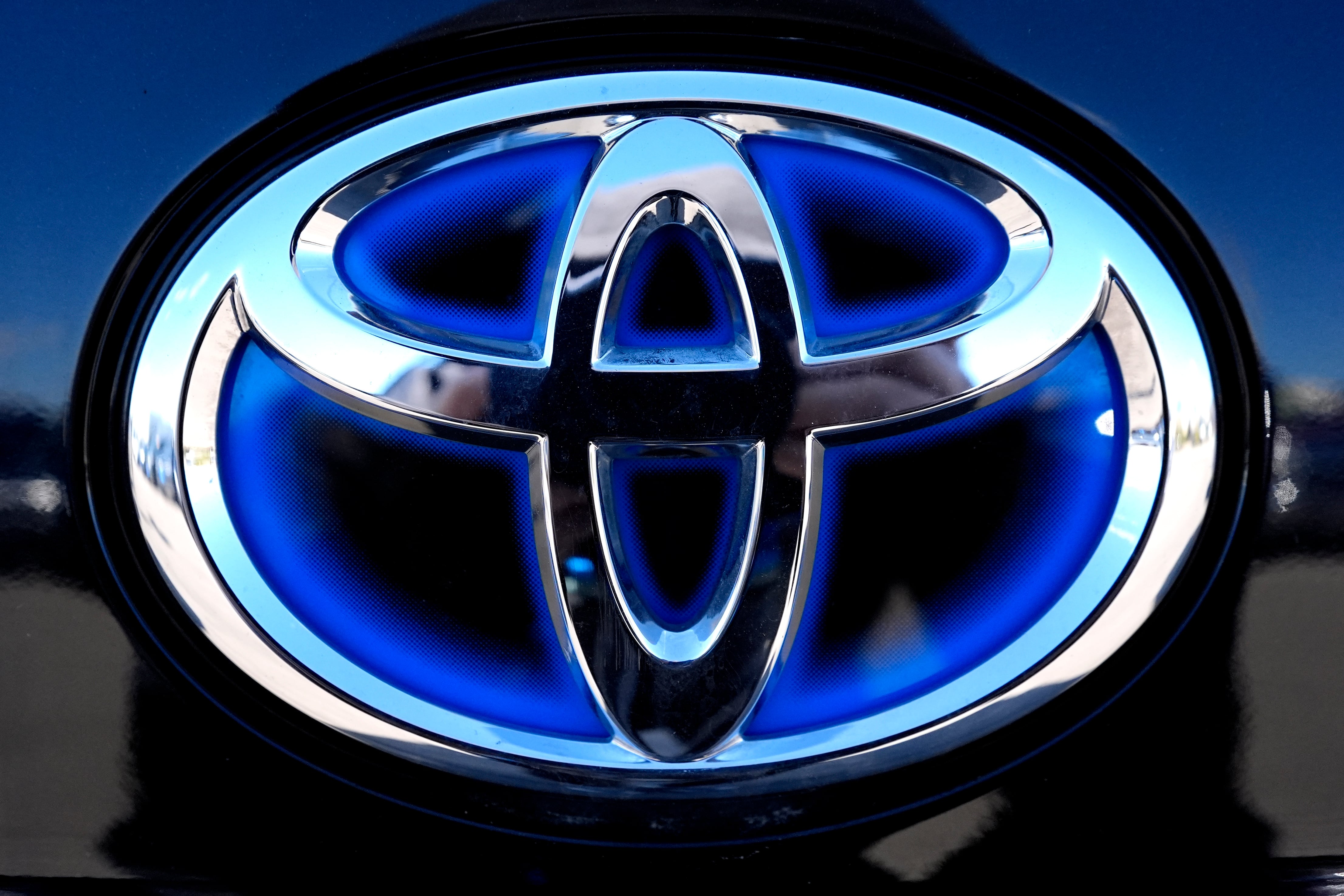 The blue Toyota logo is seen on a hybrid model at a new and used vehicles dealership in Palatine, Illinois.