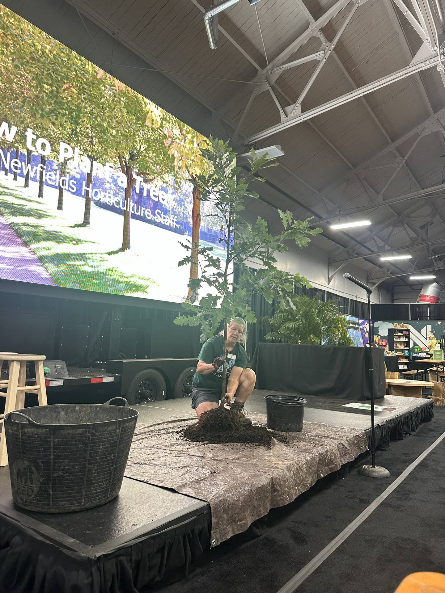 A horticulturalist from Newfields gives a demonstration on how to plant a tree at the Indiana State Fair. After visiting the 2024 event, all fairgoers can bring their ticket or program to Newfields to receive free general admission through Sept. 30.