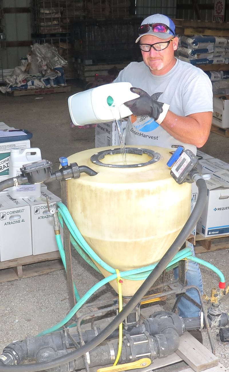 Aaron Rients made a post-application of herbicides, foliar fertilizer and fungicide on his corn last week and will follow with his first of two planned applications on soybeans. The product was poured into his mixer and then delivered to the applicator tank.