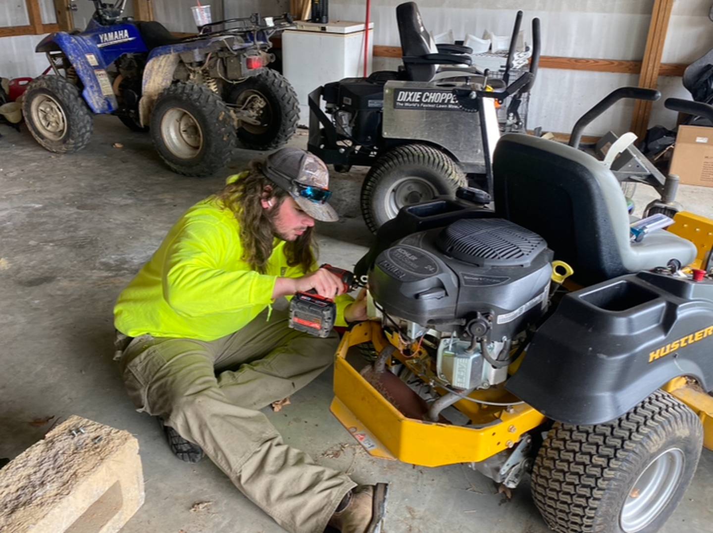 Ty Robison does maintenance work on one of his mowers that is part of his business where he mows 35 yards and one homeowner’s association and also provides landscape excavating.
