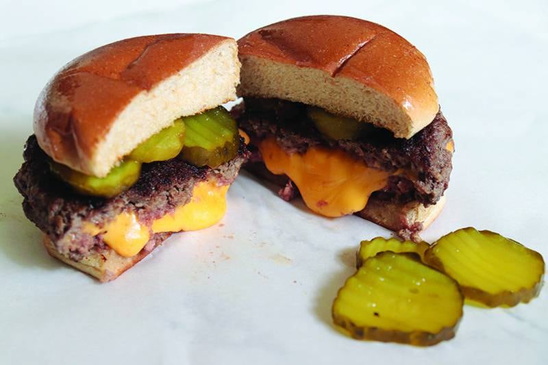 The famous Juicy Lucy burger, a favorite of Minnesotans, features melted American cheese sandwiched between two seasoned ground beef patties.