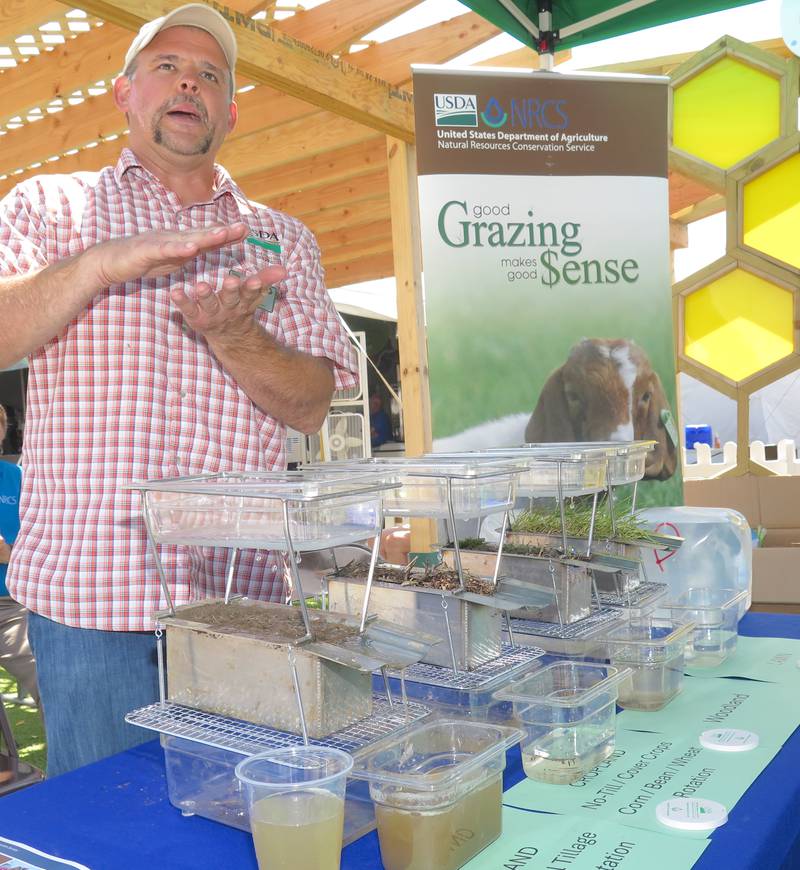 Marc Zucco, Natural Resources Conservation Service resource soil scientist, gives a water infiltration demonstration using the same soil types with different outcomes based on management practices at the Illinois State Fair.