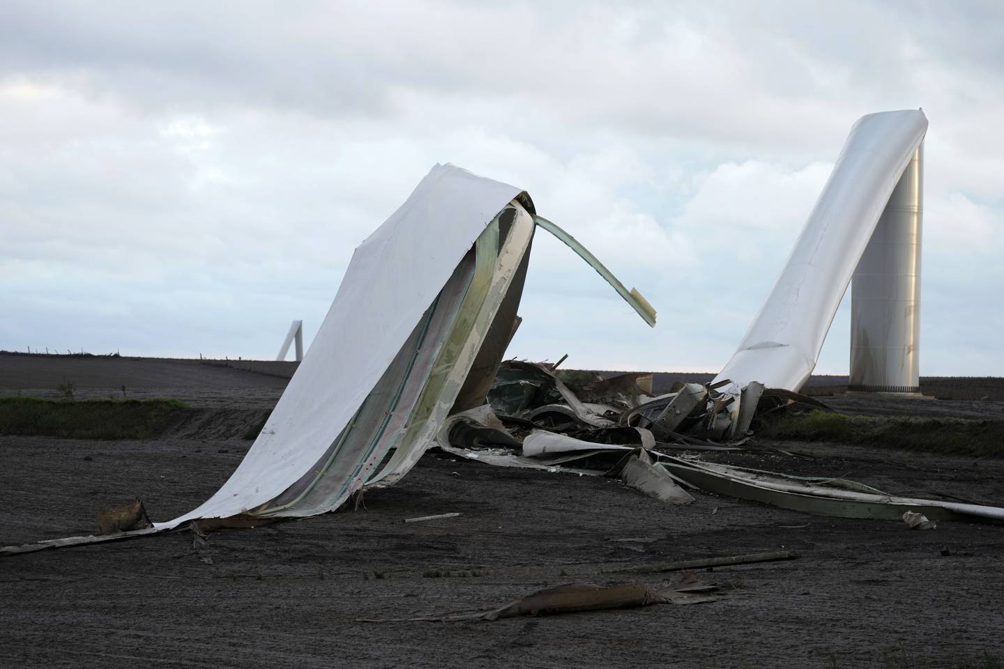 The remains of a tornado-damaged wind turbine touch the ground in a field May 21 near Prescott, Iowa.