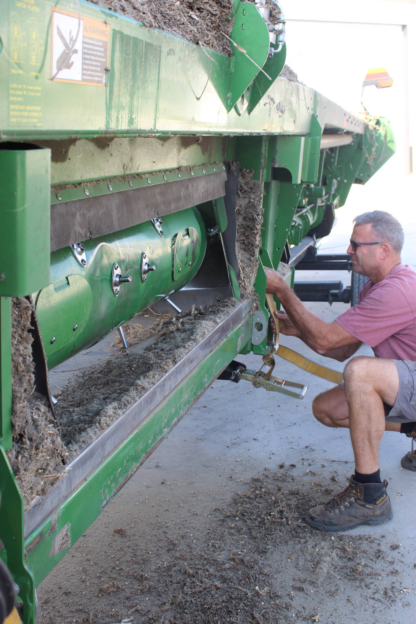 Chris Gould tightens the straps on the head mover in preparation to travel to the next soybean field on his farm in Maple Park, Illinois. He started harvest this year on Sept. 30, about a week behind most years.