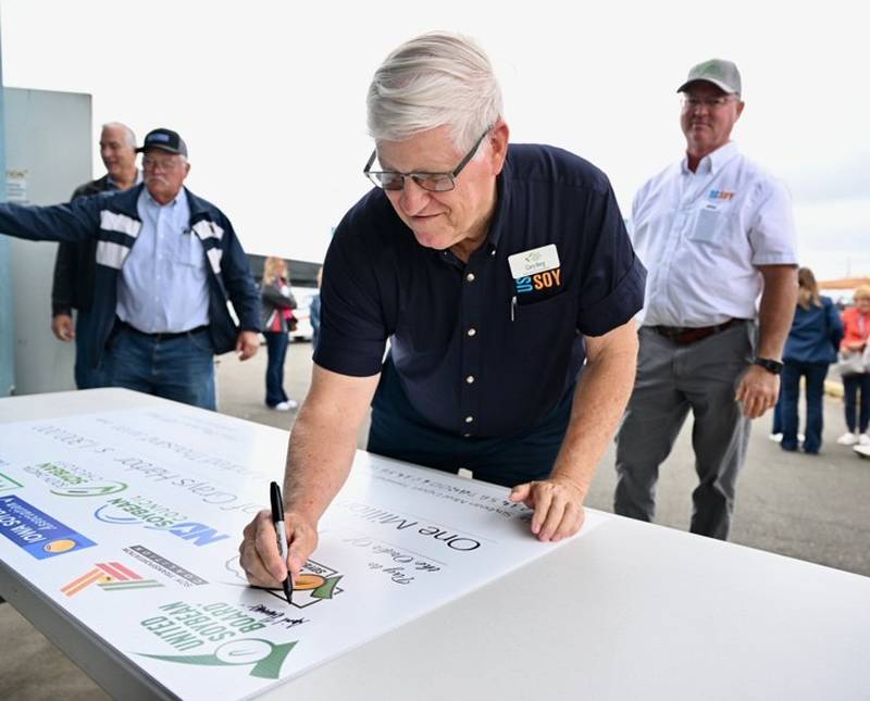 Gary Berg, farmer from St. Elmo, Illinois, and United Soybean Board director and USB Health and Nutrition Priority Area coordinator, signs the investment check that will allow the Port of Grays Harbor in the Pacific Northwest to double its soybean exports.