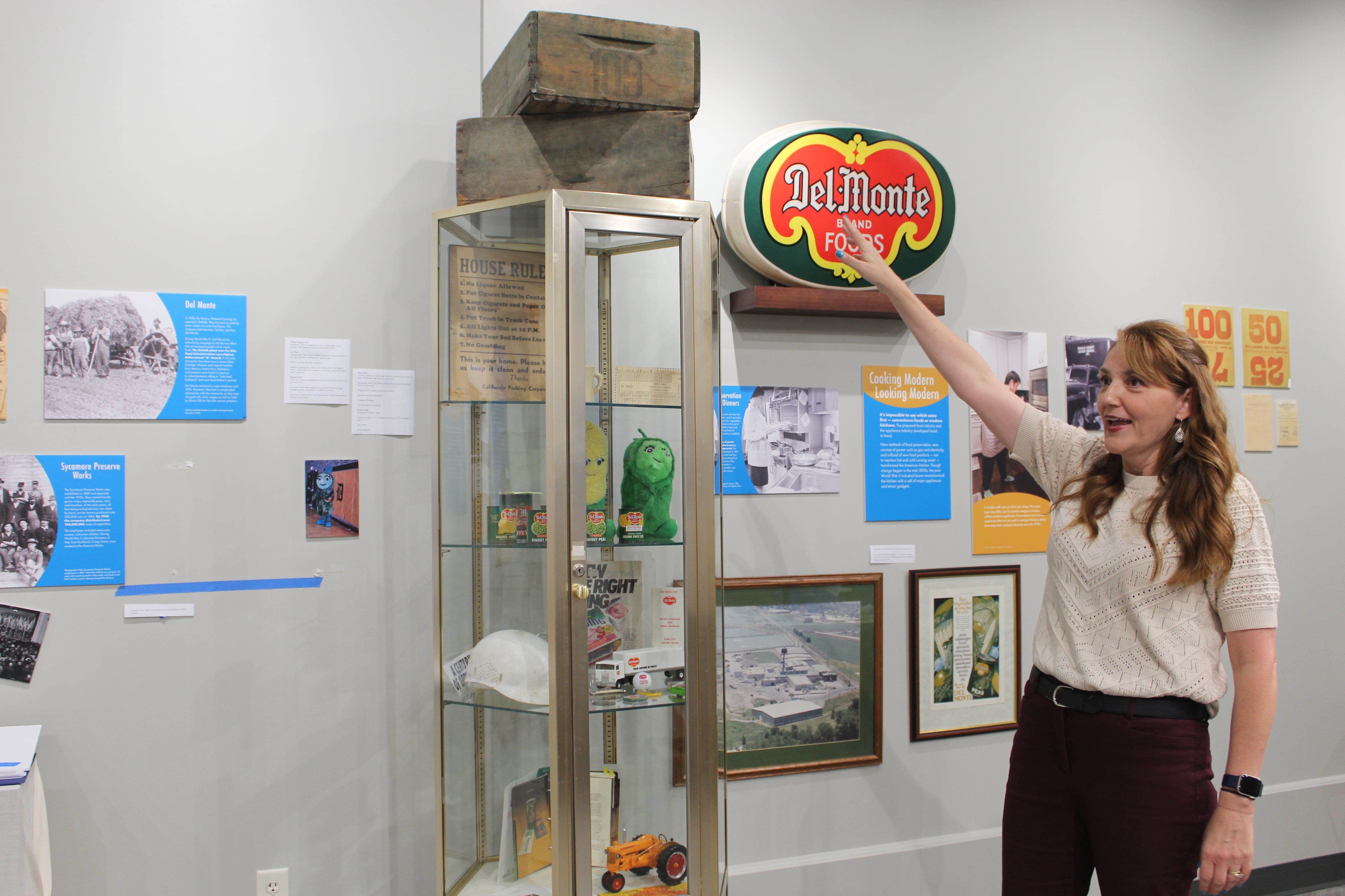 Michelle Donahoe talks about items on display in the “Food: Gathering Around the Table” exhibit from the Del Monte company that includes pea crates. The Del Monte section is one of the largest sections in the exhibit that visitors to the DeKalb County History Center will have the opportunity to see for the next two years.