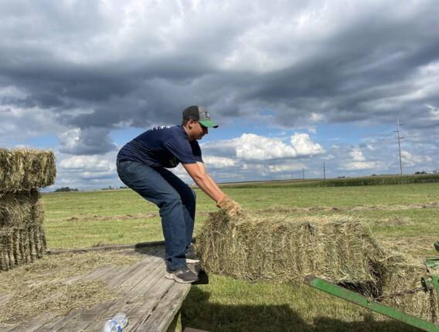 William LaFary stacks a hay bale on the rack for his hay business that he owns and operates as part of his FFA project.