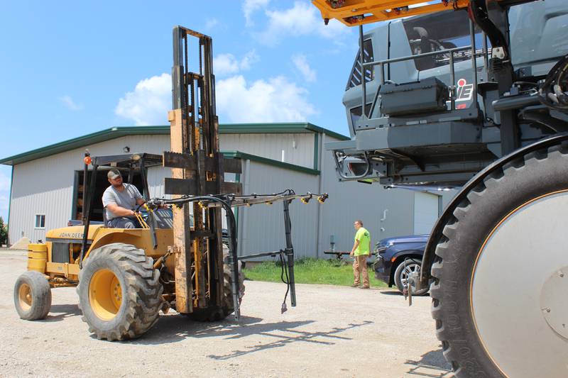 Correy Rahn maneuvers the rear boom toward the back of the Hagie sprayer in preparation for fungicide applications. He may also include insecticides if the insect pressure exceeds the threshold for crop damage.