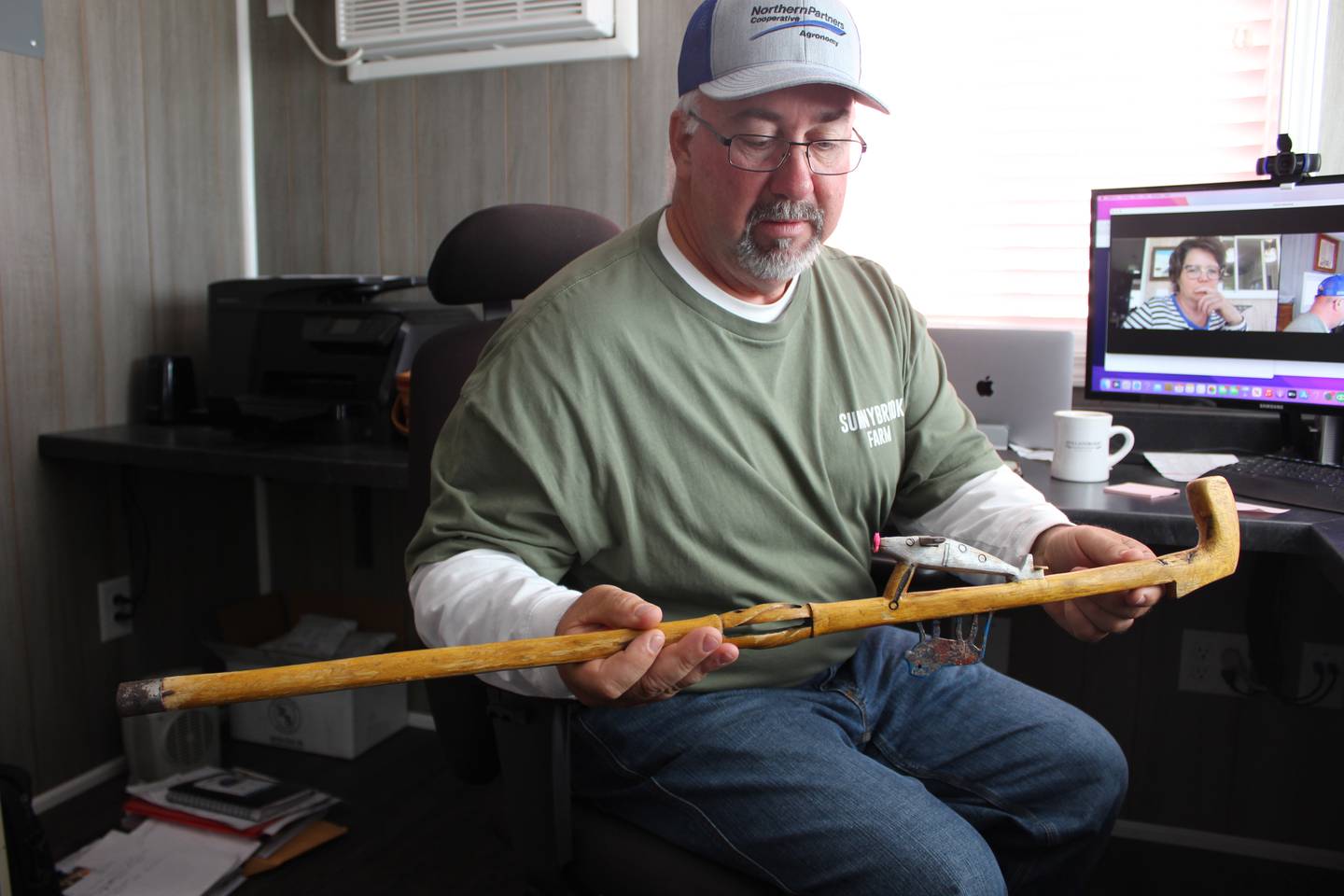 Joe Schmidt holds a cane that one of the farmers from the reformed poachers group made for him. The animal represents the poachers and the plane is for the Schmidts flying to Uganda to help the farmers improve their farming practices.