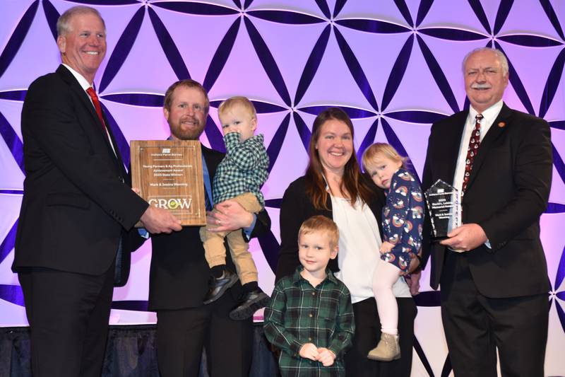 As the winners of the Achievement Award, which recognizes Indiana Farm Bureau members who earn the majority of their income from a farming operation and measures applicants on their leadership involvement and farm management techniques, Mark and Jessica Wenning will receive an $11,000 cash prize and an all-expenses-paid trip to compete at the American Farm Bureau Federation Annual Convention and Trade Show in Salt Lake City in January. The Wennings, pictured with their children, Joel (from left), Noah and Molly, were bestowed the Achievement Award at the INFB State Convention by Indiana Farm Bureau Insurance Executive Vice President and CEO Kevin Murphy, as well as the the David L. Leising Memorial Award by INFB President Randy Kron (right).