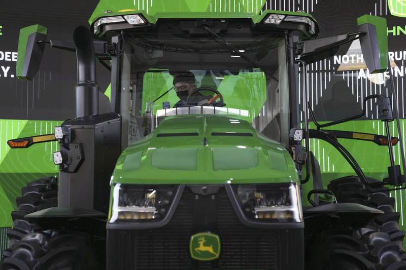 An attendee looks at a John Deere automated tractor at the John Deere booth during the 2022 CES tech show in Las Vegas.